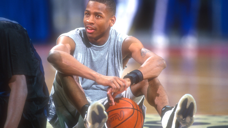 Allen Iverson sitting on court basketball smiling