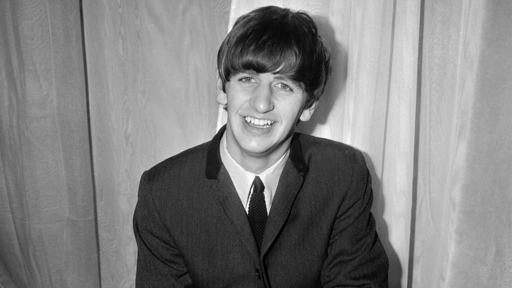 young Ringo Starr wearing suit and smiling in 1963