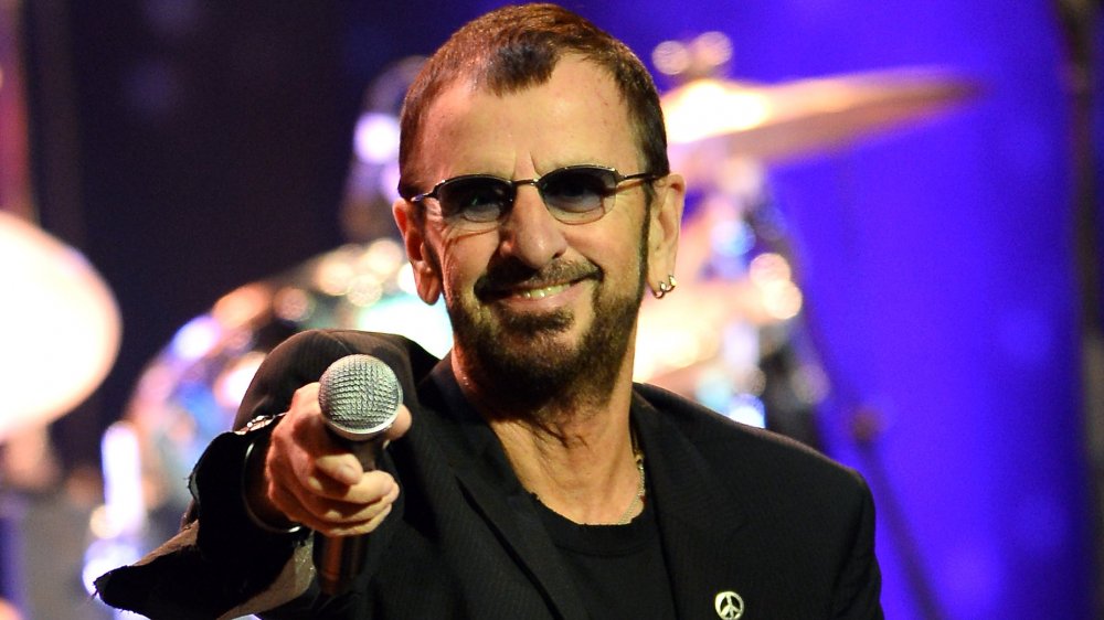 Ringo Starr smiling holding microphone