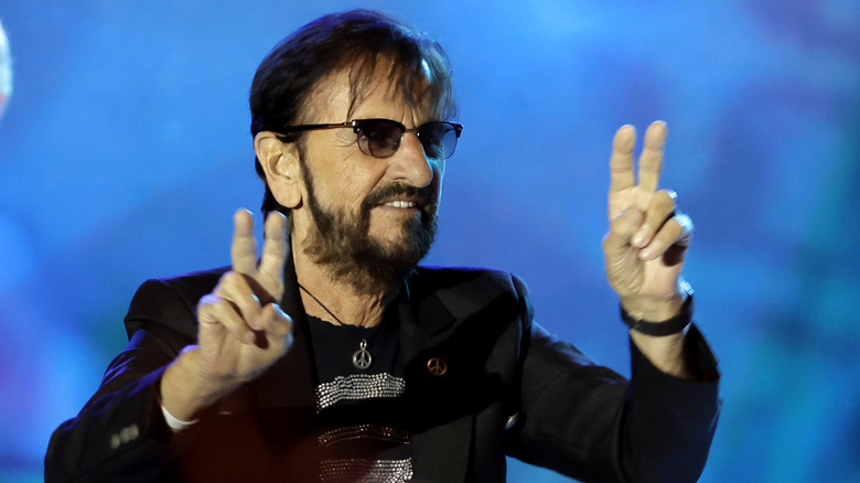 Ringo Starr flashing double peace signs