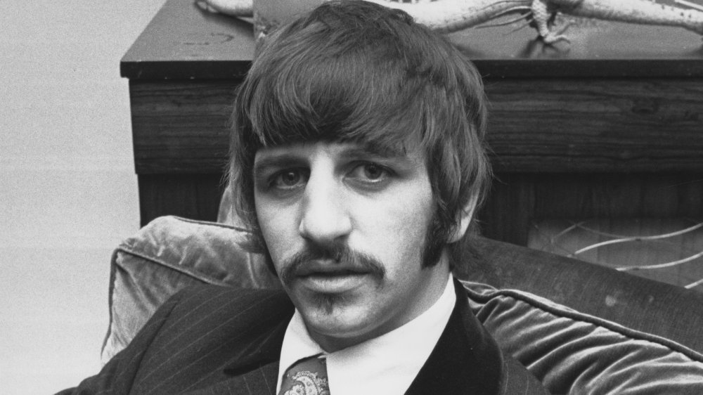 Ringo Starr with mustache sitting on couch in 1967
