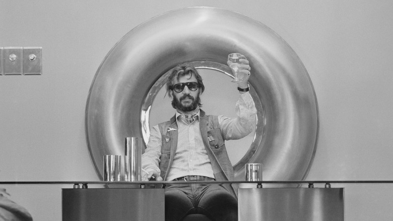 Ringo Starr raising a glass and sitting in a big O at Ring O' Records launch