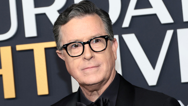 Stephen Colbert wearing a black suit