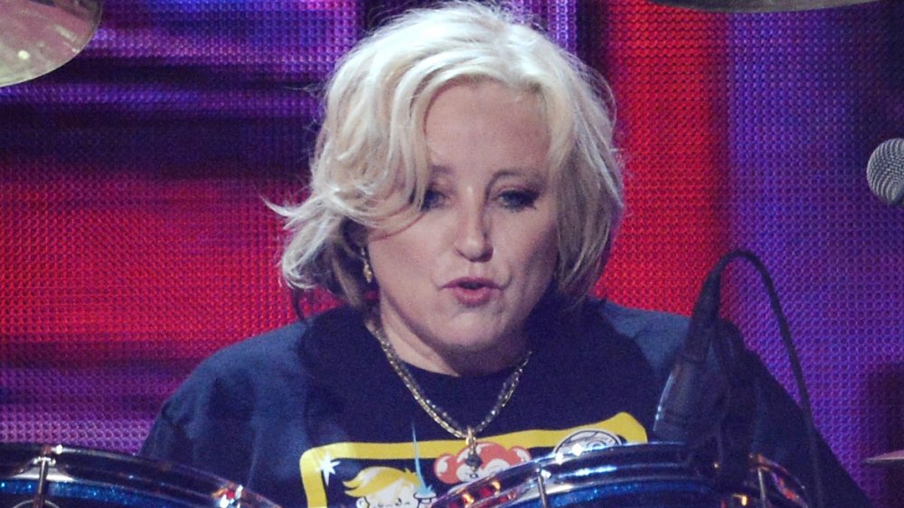Gina Shock at drums pursed lips on stage