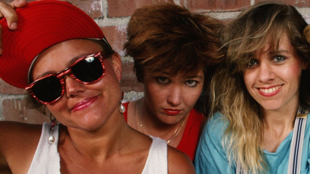 The Go-Go's posing by brick wall