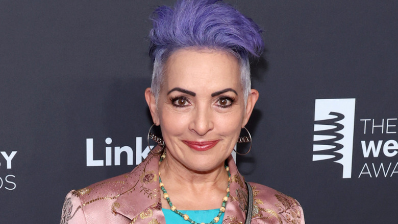 Jane Wiedlin smiling with purple hair