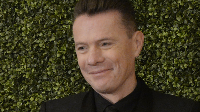 Larry Mullen staring off smiling