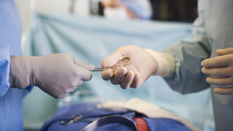 surgeons passing scapel