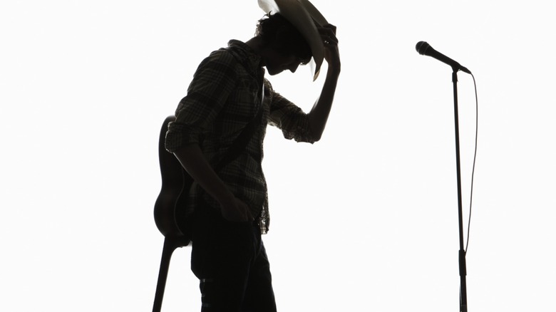 silhouette of man holding guitar