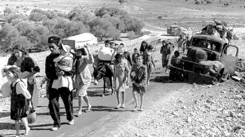 Uchodźcy palestyńscy spacerujący po pustyni