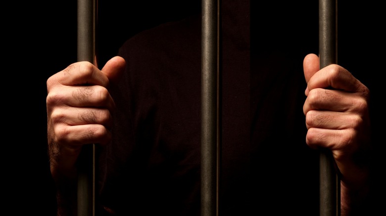 hand of prisoner on cell bars