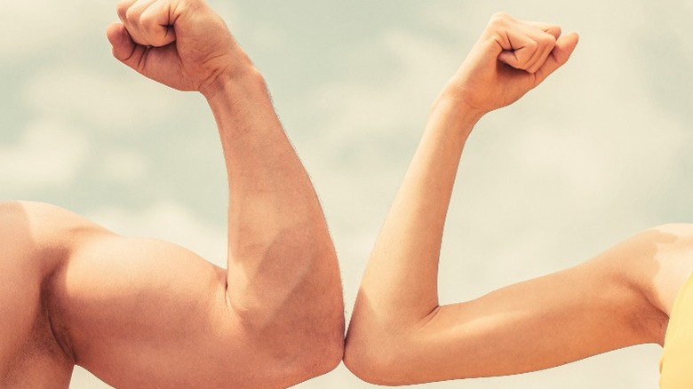 man and child flexing bicep muscles