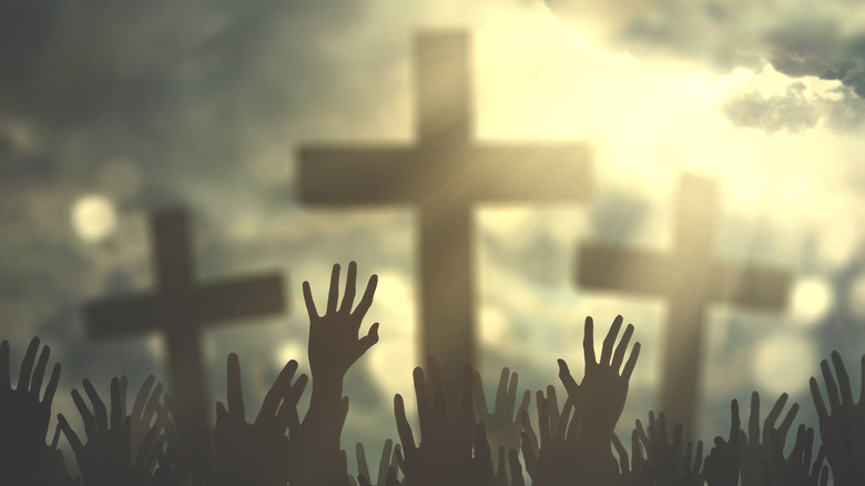 Hands raised to three crosses