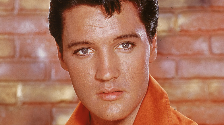 Elvis Presley wearing an orange shirt