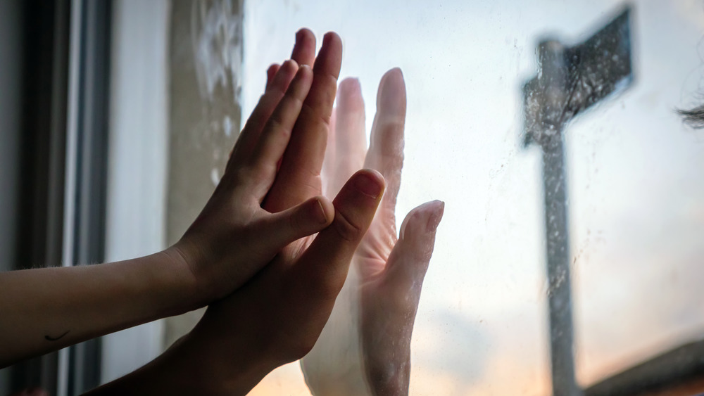 Hands touching on a window