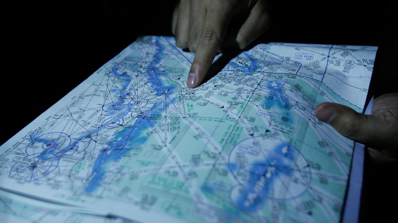 Hand pointing map showing possible MH370 flight path during 2014 search mission