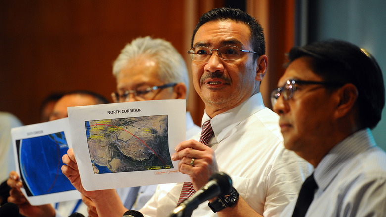Malaysia's acting minister of transport Hishamuddin Hussein holds up maps during press conference concerning MH370, March 17, 2014