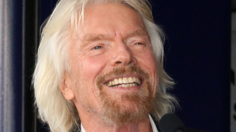 Richard Branson smiles at a podium.