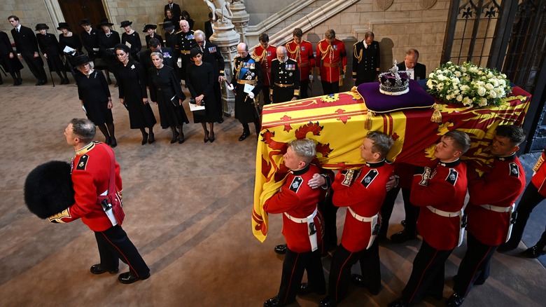 queen elizabeth's coffin being carried by soldiers