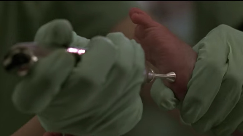 A nurse taking a blood sample from a baby's foot 