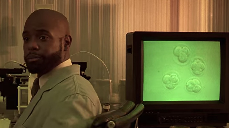 Geneticist in Gattaca showing a monitor with embryos
