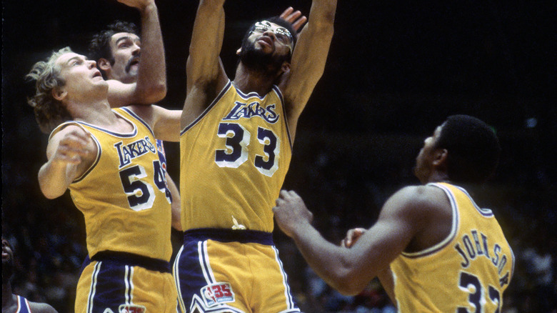 Mark Landsberger, Kareem Abdul-Jabbar, and Magic Johnson fight for rebound