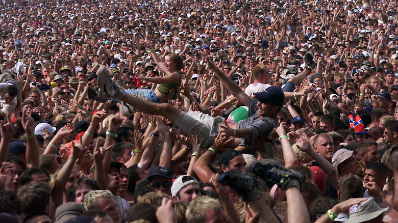 Man and woman crowd surfing
