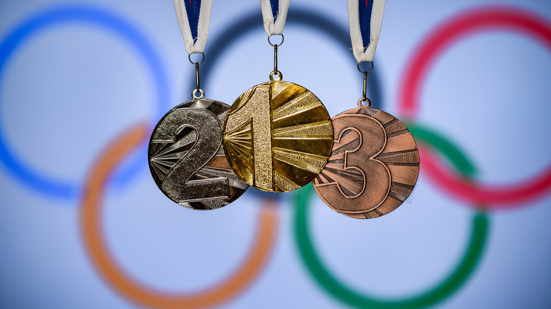 Olympic medals in front of Olympic flag