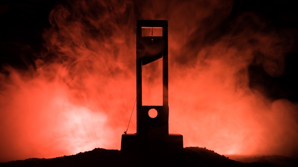A photograph of a guillotine surrounded by smoke.