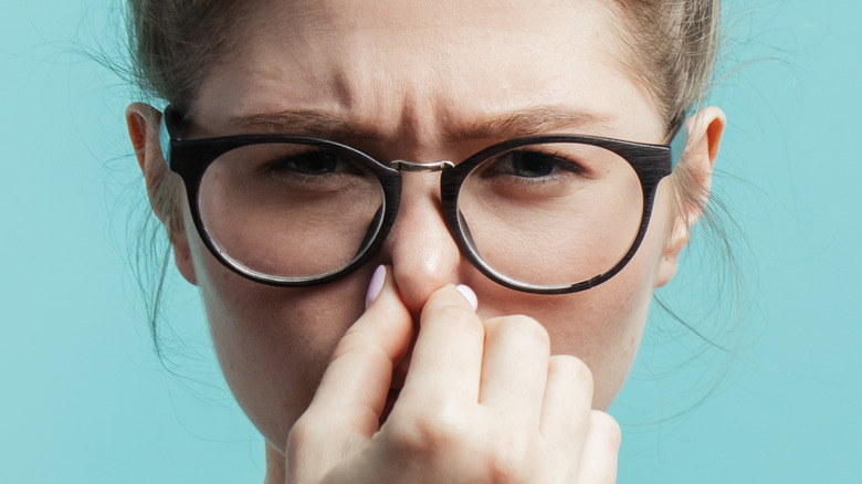 Person holding nose against bad smell