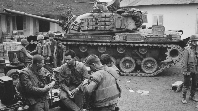 U.S. soldiers sitting by tank