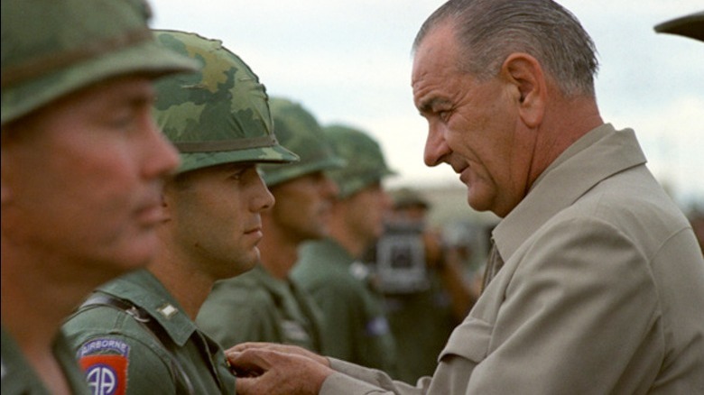Johnson pinning medal on soldier