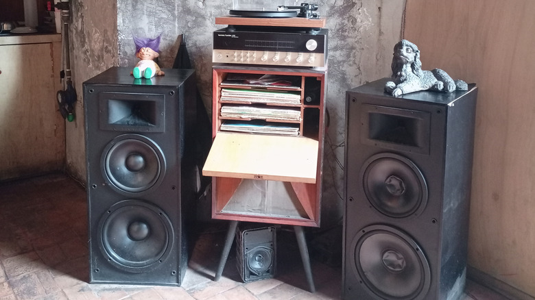 Speakers standing next to vinyl stand