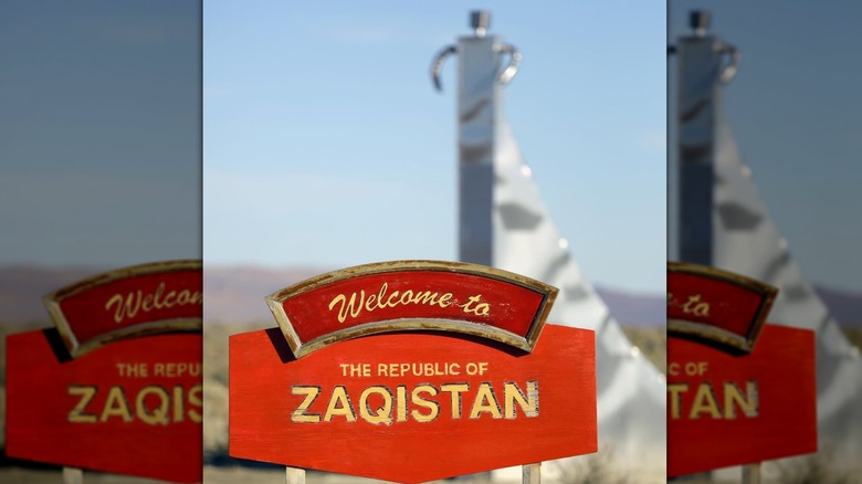 A close-up of the Welcome to the Republic of Zaquistan sign in front of an art installation