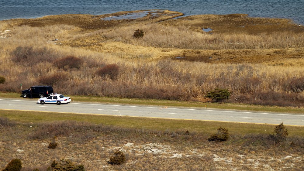 Cop car investigating the scene at Gilgo Beach