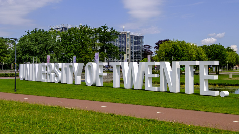 Outside view of The University of Twente sign in big white letters on grass