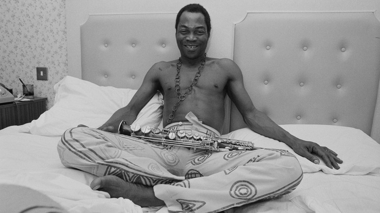 Fela Kuti in hotel room with saxophone