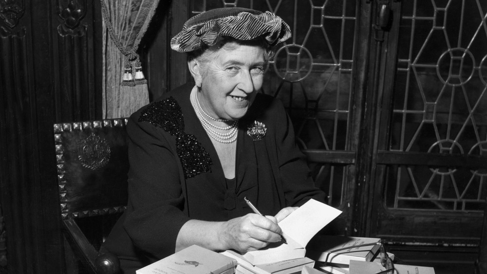 Agatha Christie autographing copies of her book 