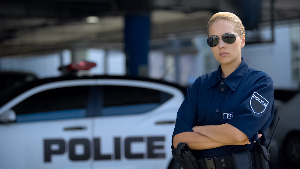 Serious policewoman in front of cruiser