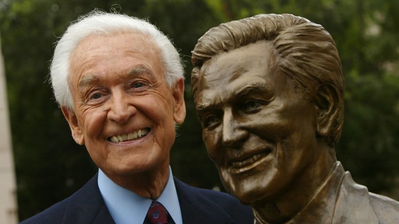 Bob Barker posing next to statue of himself