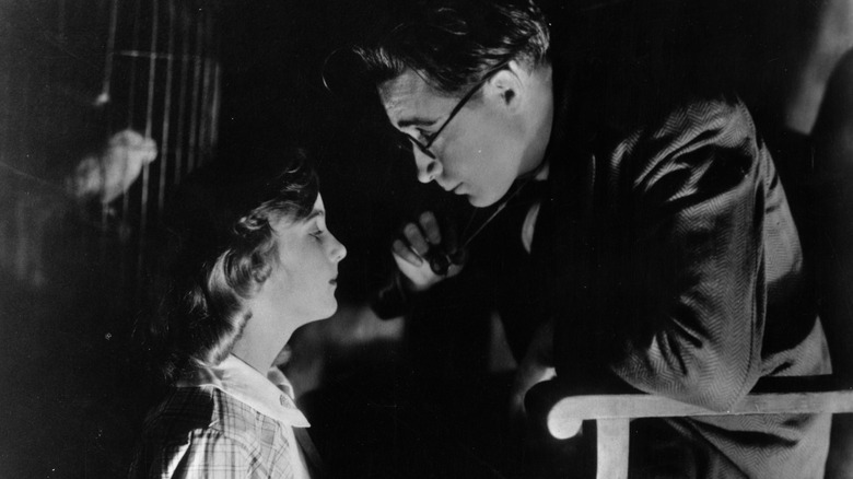 Young Carole Lombard on a film set, looking at director