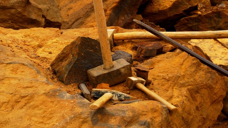 Several hammers lying on orange rock
