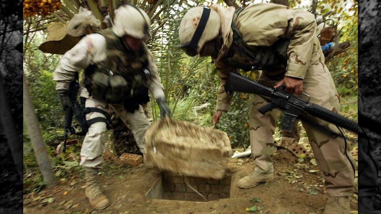 Soldiers lifting cover on Hussein's hideout