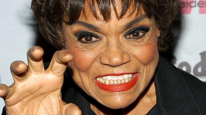 Eartha Kitt grinning with her hand up like a cat paw