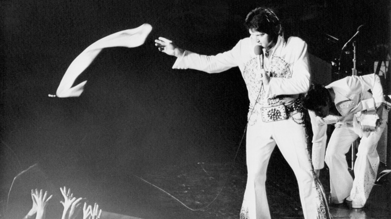 Elvis Presley throwing his scarf into the audience