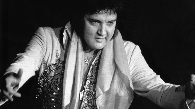 Elvis Presley gesturing on stage in 1977