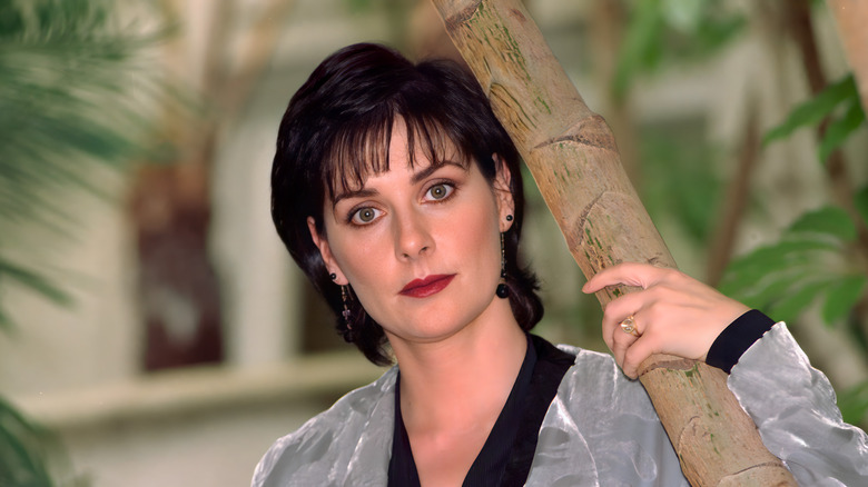 Enya holding tree trunk