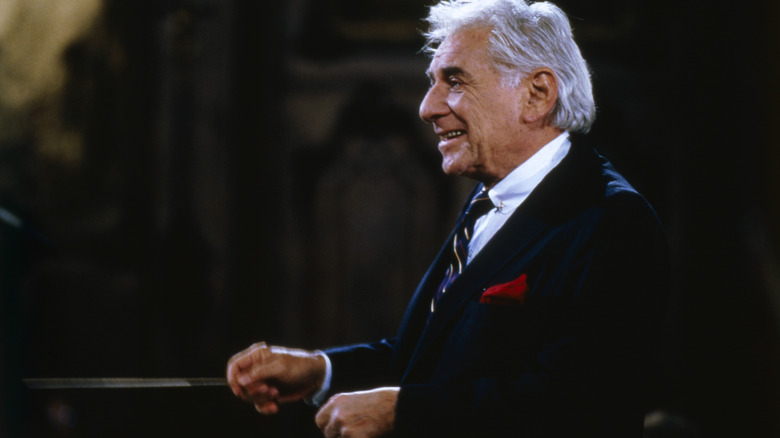 Older Leonard Bernstein dark suit baton smiling conducting