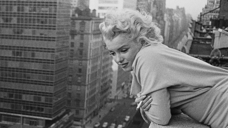 Monroe leans over the balcony in New York