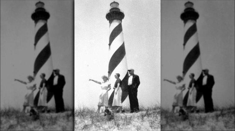 Marjory Stoneman Douglas standing in front of lighthouse with two other people, pointing